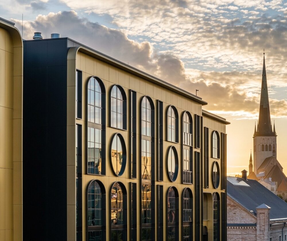 Golden Gate facade at sunset with a church spire of Tallinn Old Town behind