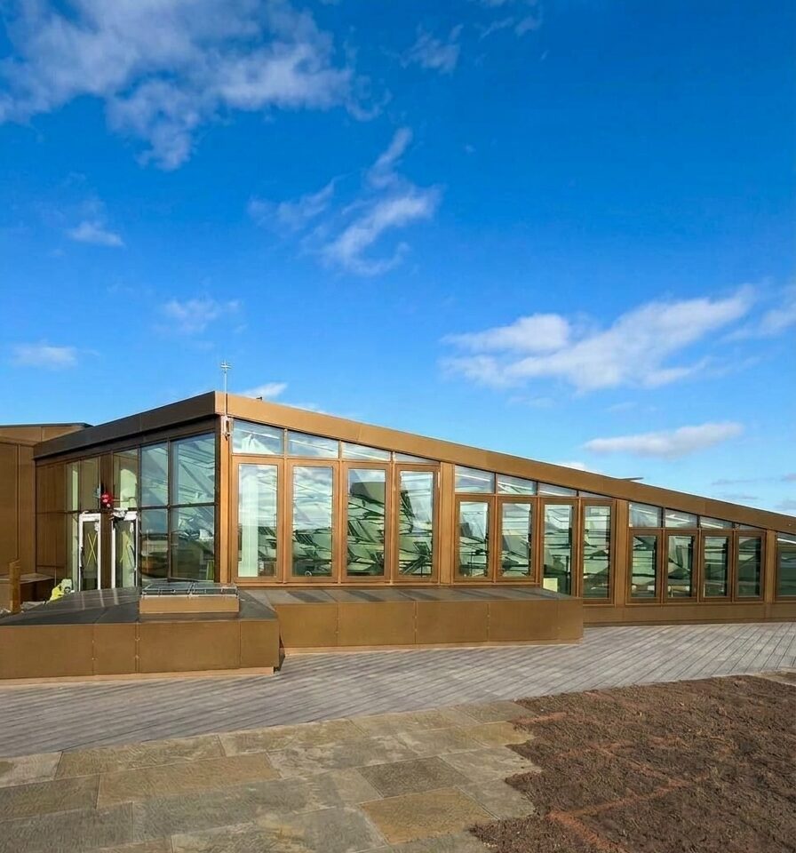 Glazed rooftop pavilion of Snäckan 8 under a blue sky